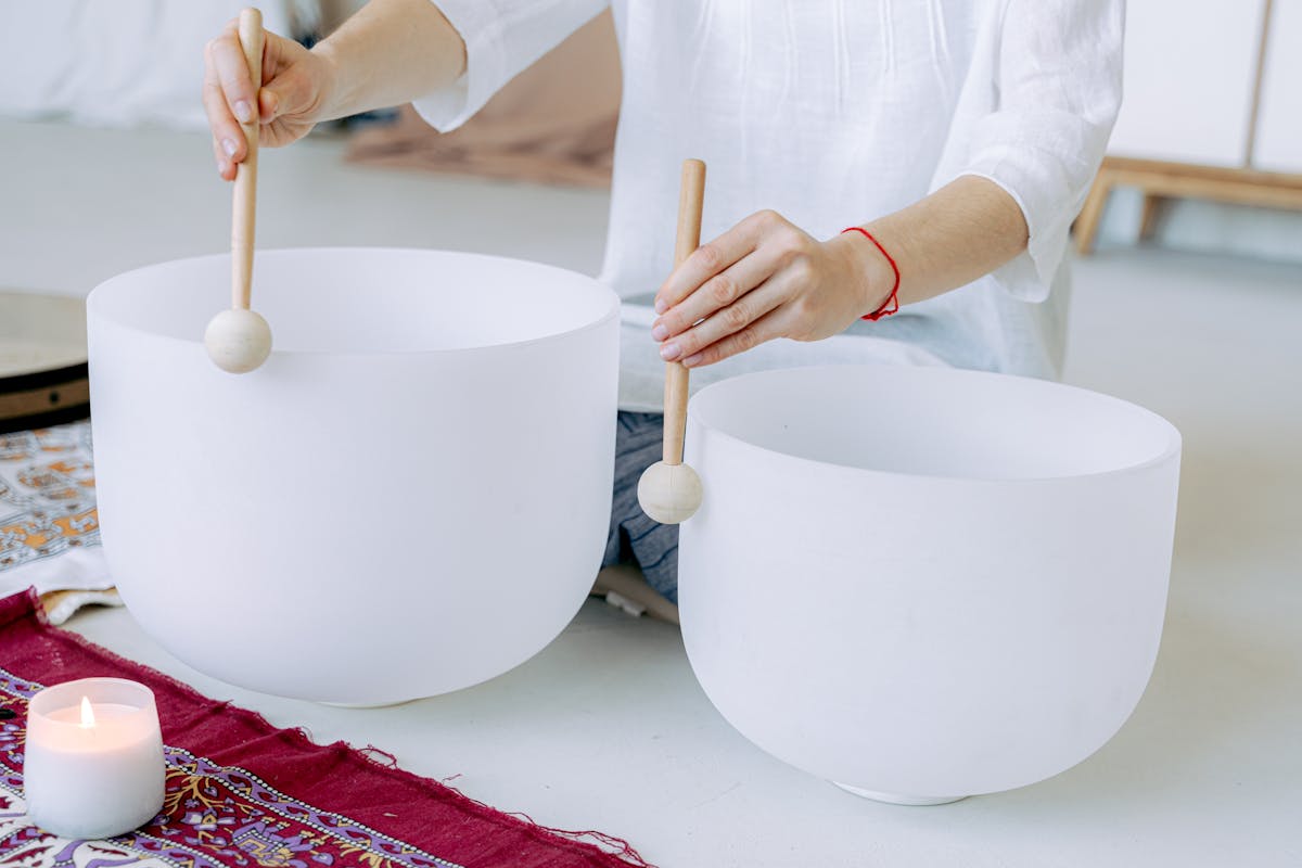 A person holding sticks and creating vibrations for healing